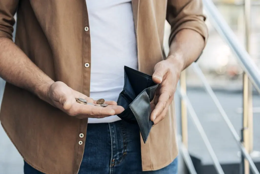 close up hands holding wallet coins