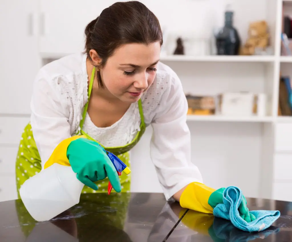 Mulher limpa bancada da cozinha