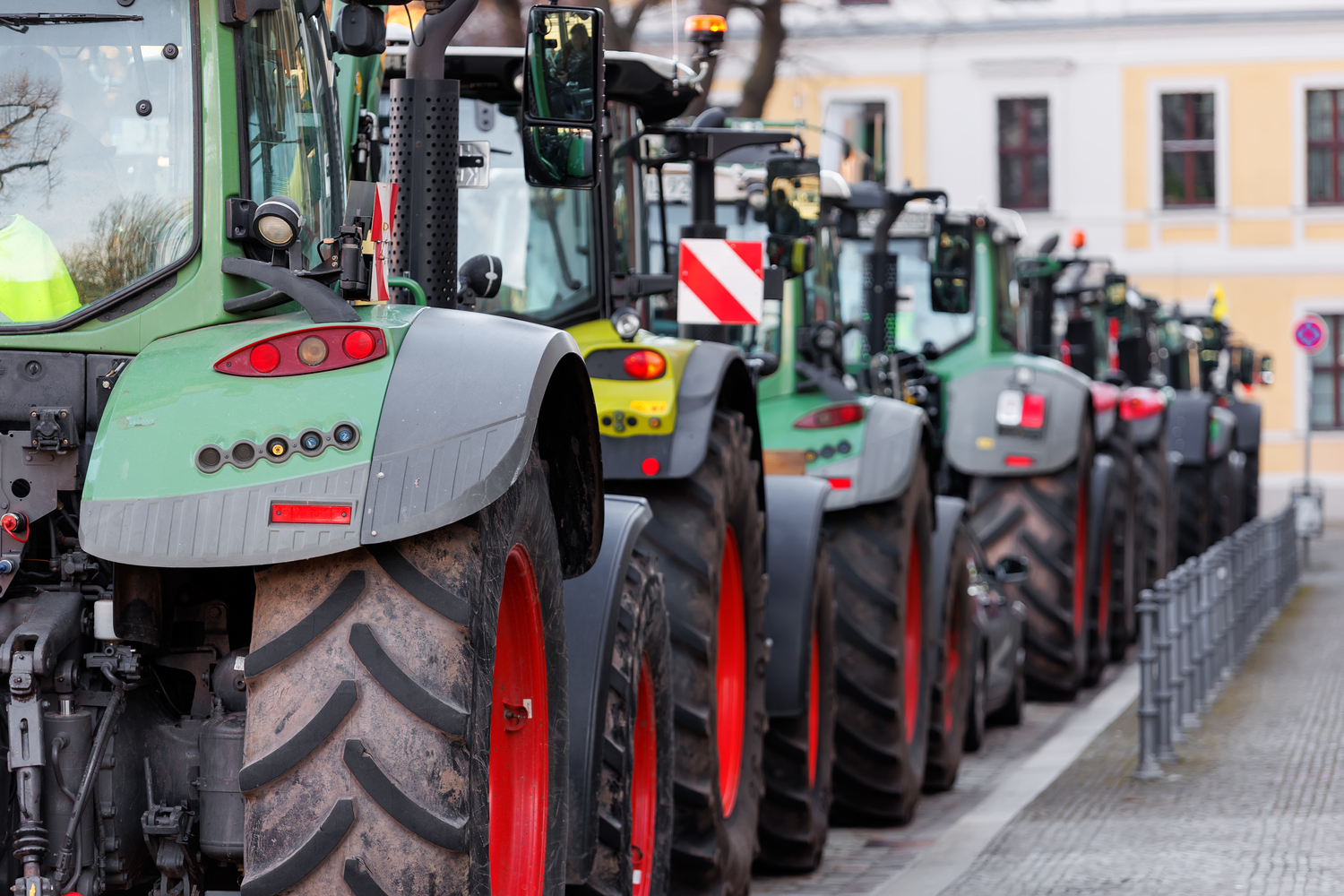 Farmers union protest strike against government Policy in Germany Europe. Tractors vehicles blocks city road traffic. Agriculture farm machines Magdeburg central Domplatz square.